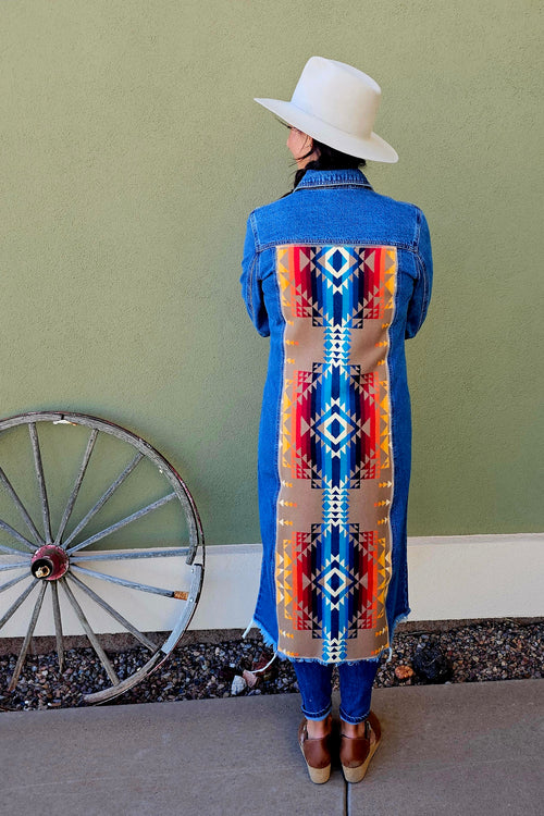 Back view of the Pilot Rock denim duster with a long multicolored geometric wool panel from shoulders to hem.