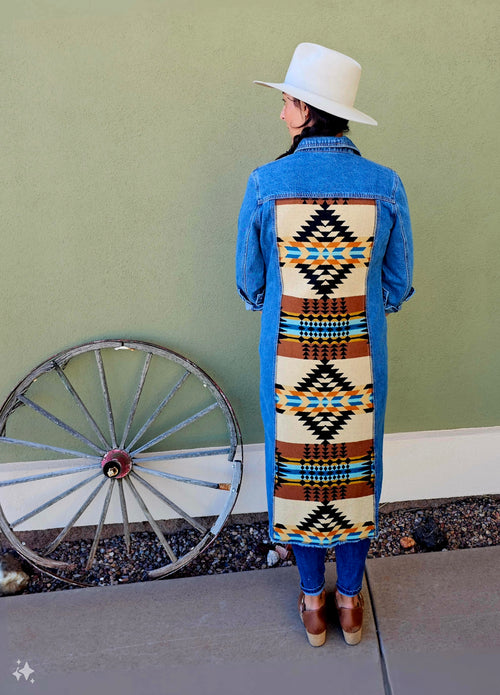 Back view of the Rancho Arroyo Black denim duster with a long cream, black and rust geometric wool panel.
