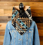 Front view of the Black/Tan geometric cowl on a mannequin wearing a denim jacket.