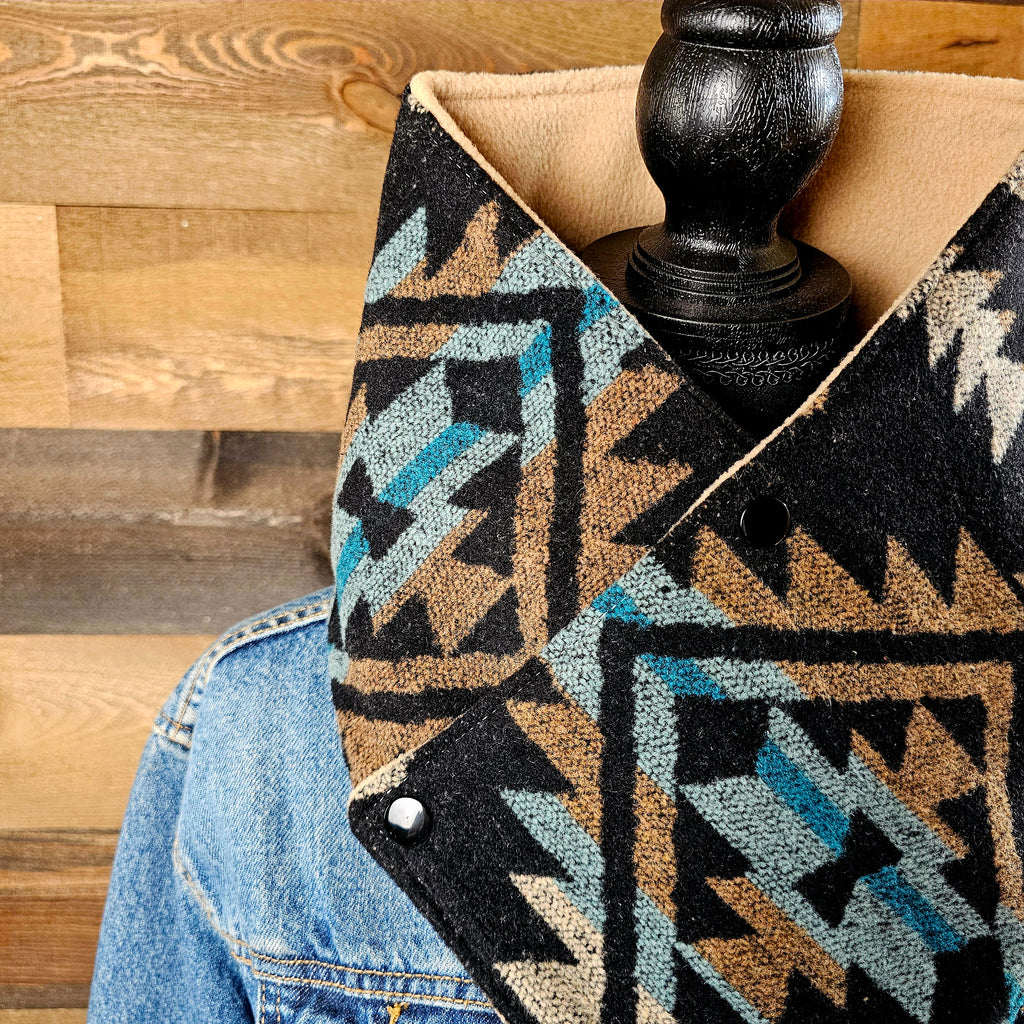 Close-up of the Black/Tan cowl showing black, tan and blue geometric fabric around a mannequin neckline.