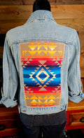 Pilot Rock denim jacket on a mannequin, showing its blue diamond and red-and-gold geometric wool back panel.