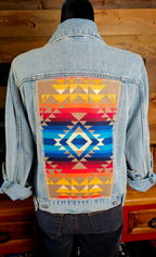 Pilot Rock denim jacket on a mannequin, showing its blue diamond and red-and-gold geometric wool back panel.