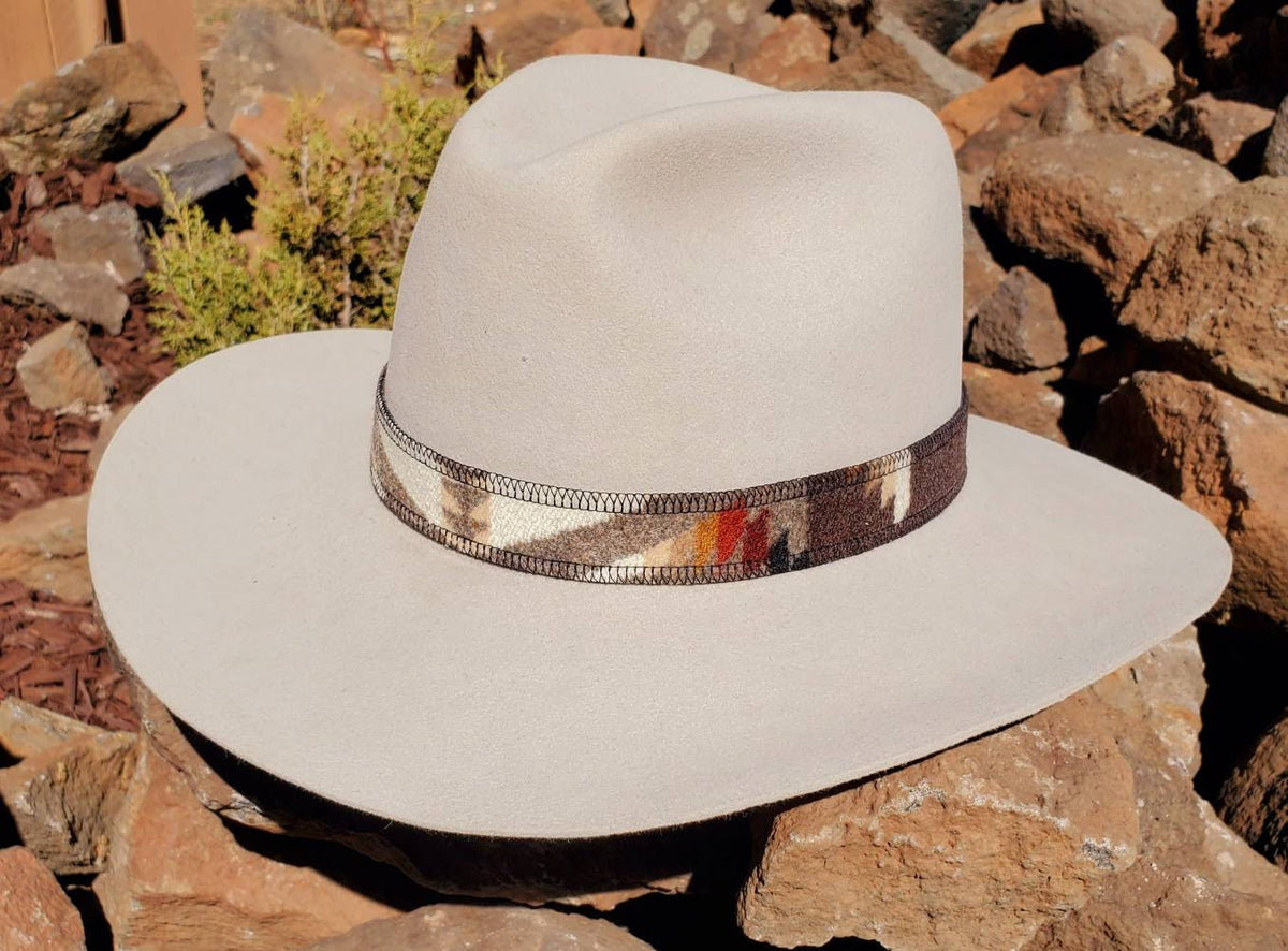 Angled view of a light felt hat showing the brown, cream and rust pattern of the Pacific Crest wool hat band.