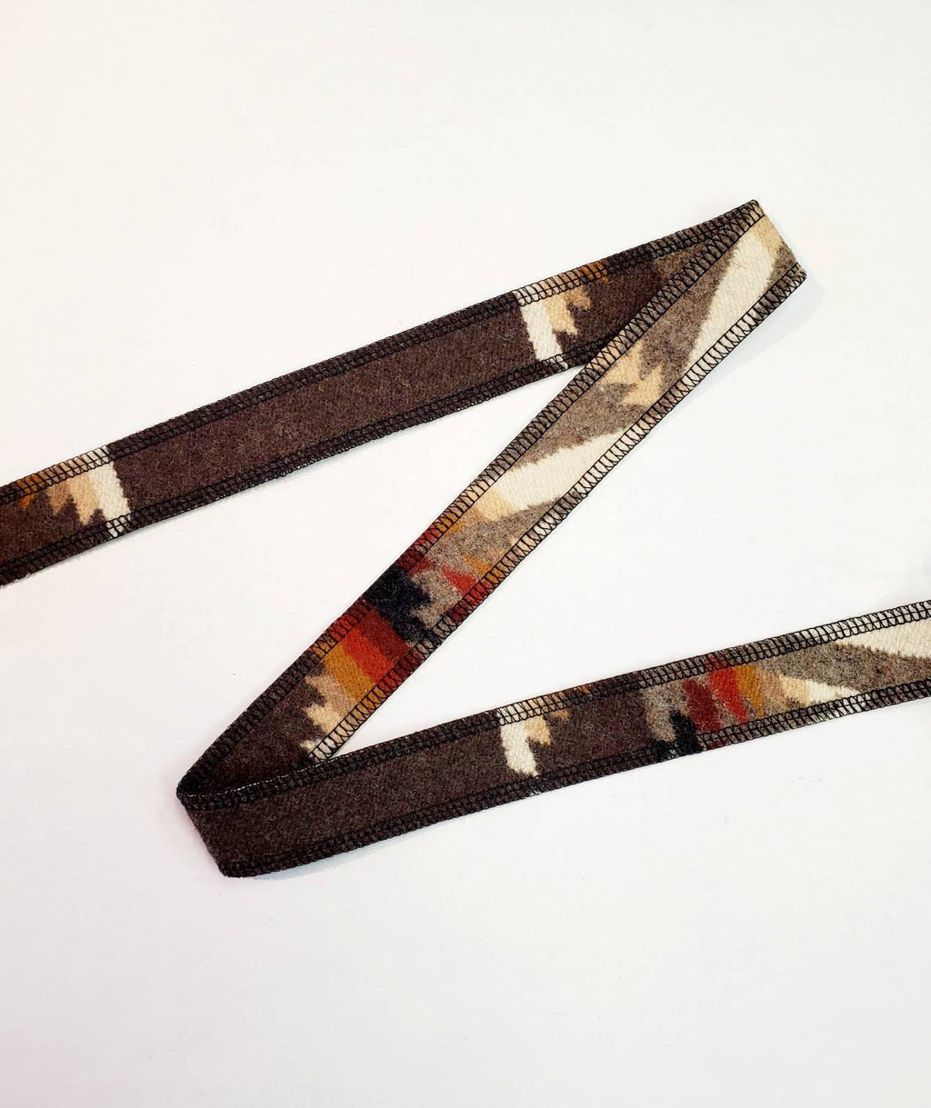 Pacific Crest wool hat band folded on a white background to show its brown geometric pattern and finished edges.