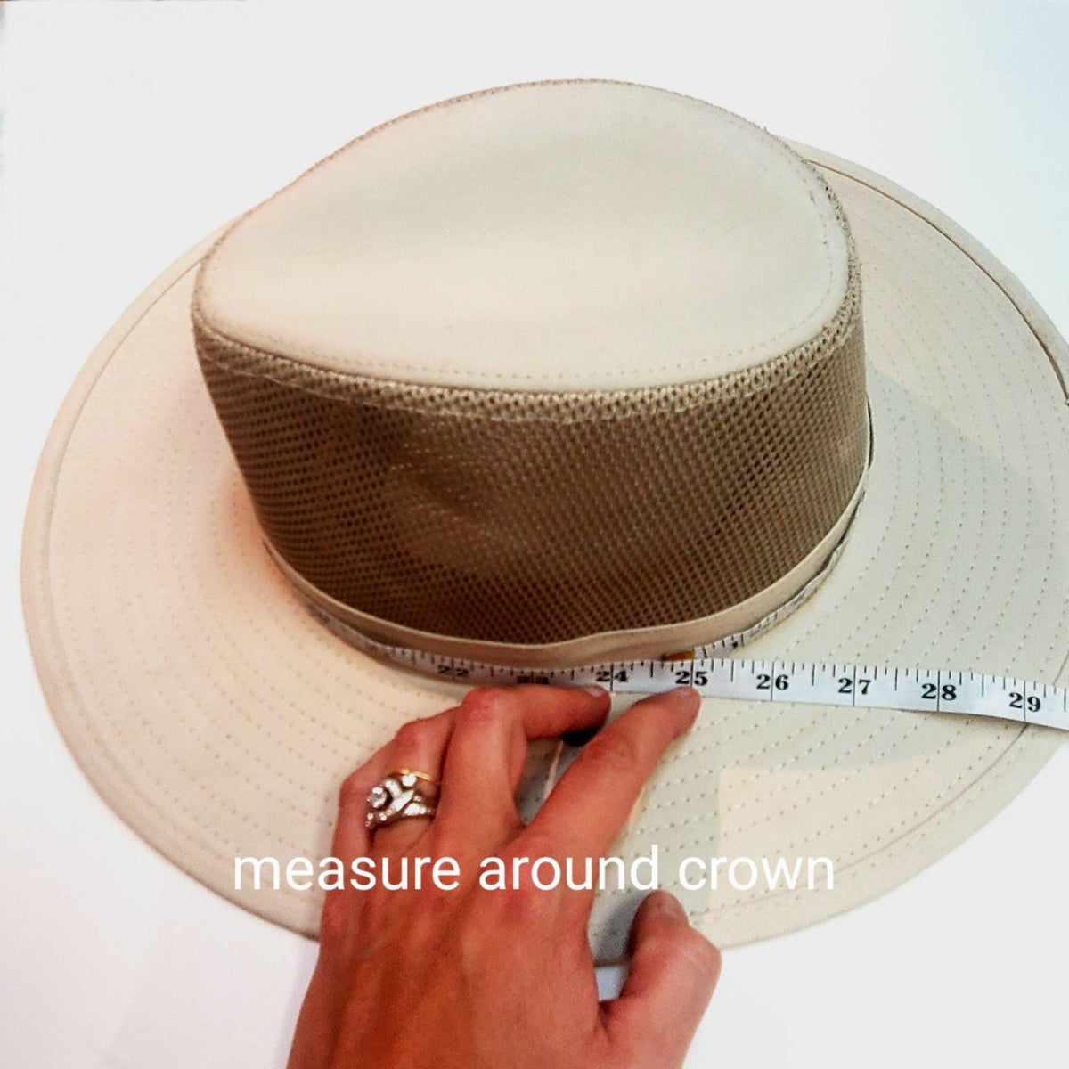 A measuring tape wrapped around a hat crown to measure the required hat band length.