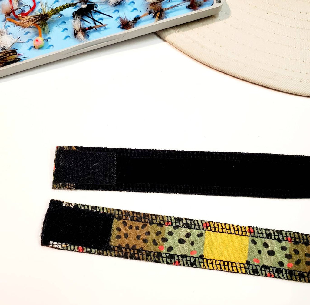 Close-up of the dark hook-and-loop fastening on the Monster Brown trout-patterned hat band.