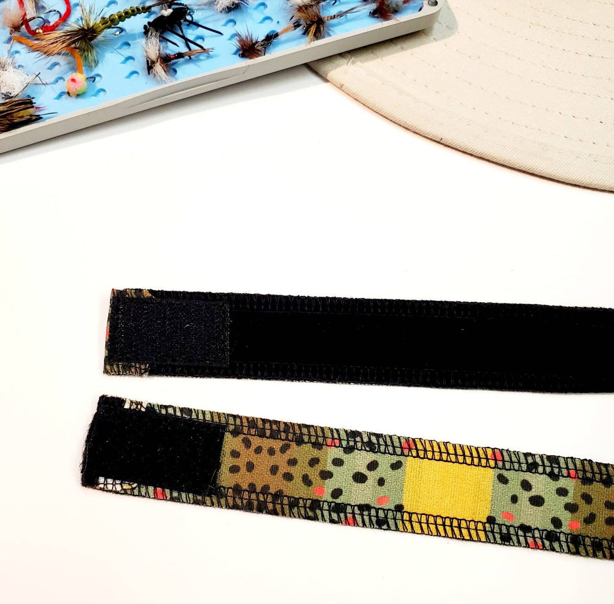 Close-up of the dark hook-and-loop fastening on the Monster Brown trout-patterned hat band.