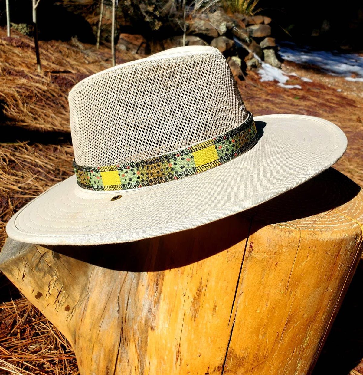 Front view of a light mesh-crown hat with the yellow and speckled Monster Brown trout hat band.