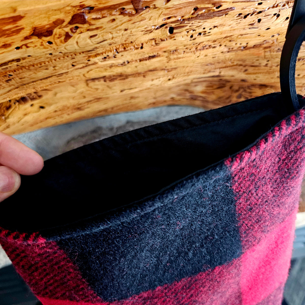 Close-up of the black interior at the opening of a red and black buffalo check Christmas stocking.