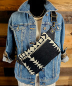 Condensed White western sling styled diagonally across a denim jacket on a mannequin.