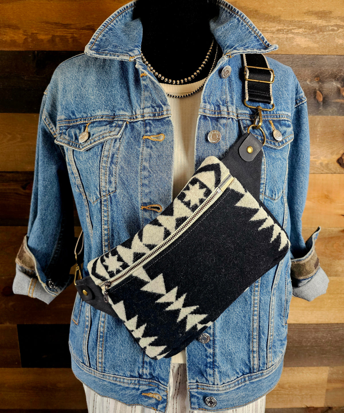 Condensed White western sling styled diagonally across a denim jacket on a mannequin.