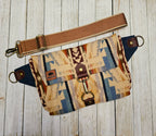 Shonto Wheatlands sling laid flat with a brown strap, geometric wool fabric and exterior zip pocket.
