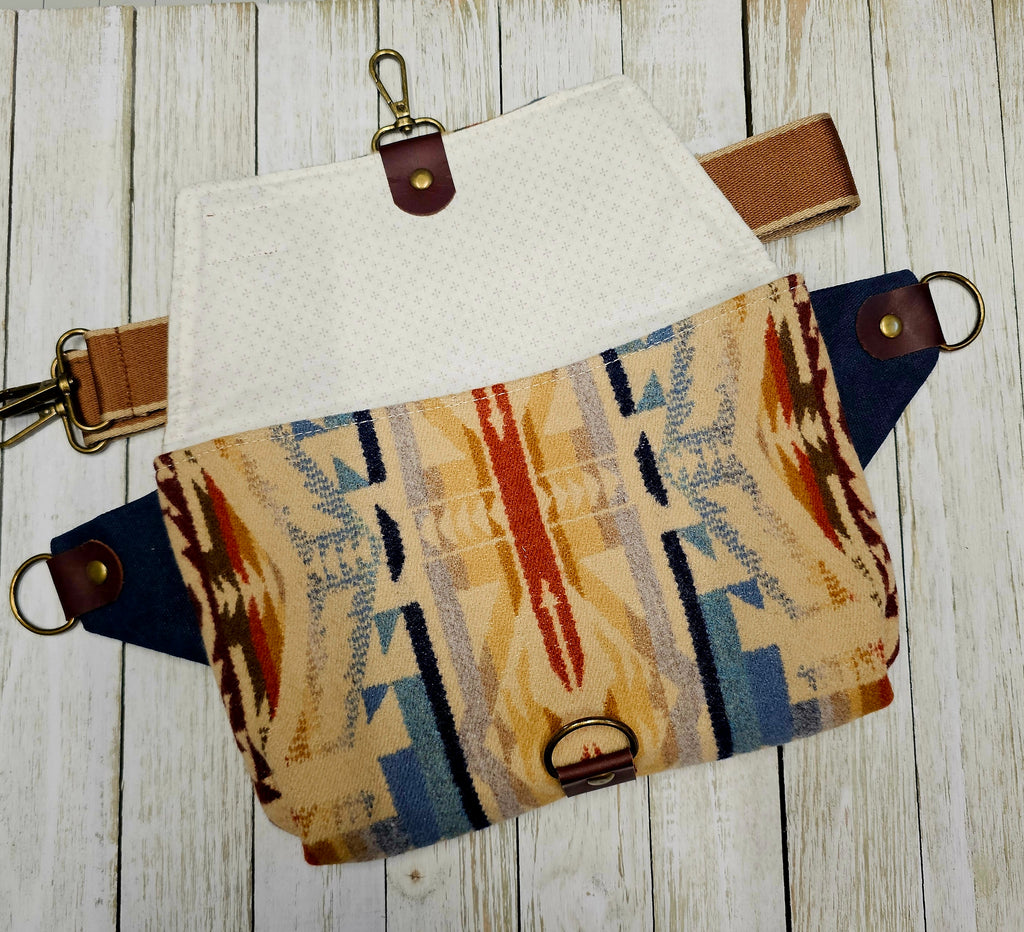 Shonto Wheatlands sling shown flat with its patterned fabric panels and brown strap detached.