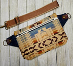 Shonto Wheatlands crossbody sling laid flat, showing geometric fabric, brown strap and zipper detail.