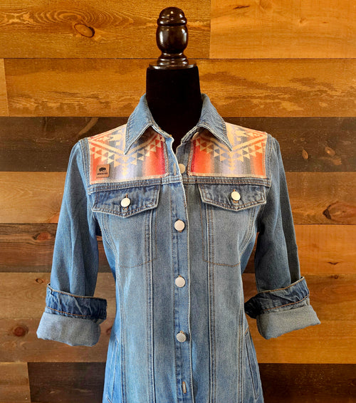 Front detail of the Canyonlands denim duster on a mannequin, showing patterned shoulder panels and button closure.